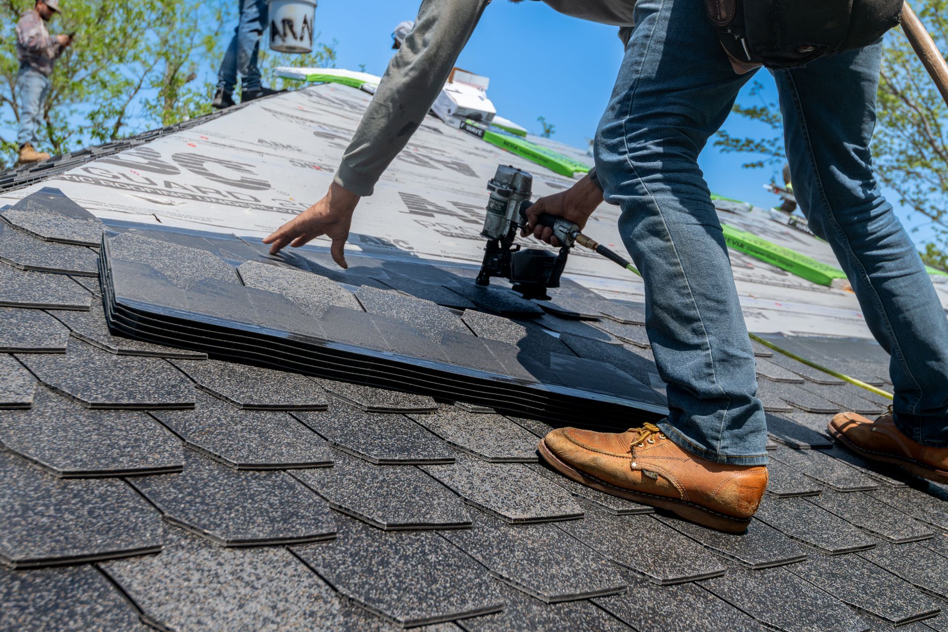 Roofer marking hail bruises with chalk on an asphalt shingle roof in Tulsa
